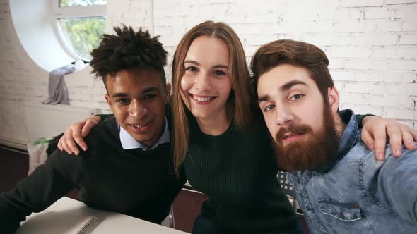 Smiling Casual Business Team Posing While Taking Selfies in the Office