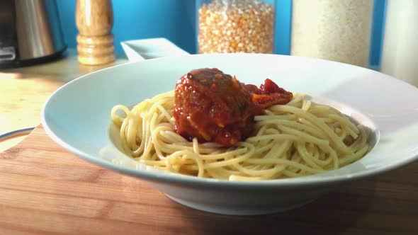 Fresh Homemade Meatballs Being Added to Spaghetti on Kitchen Counter