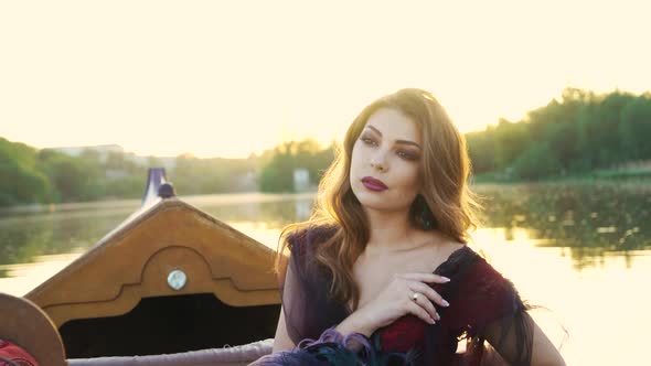 Уoung Woman in a Red Dress in a Boat on the River