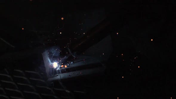 Slow motion of sparks flying from arc welder.