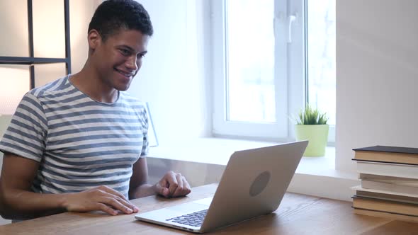 Video Chat on Laptop by Young Black Man