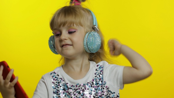 Child Dances with Smartphone, Listening To Music on Headphones. Little Kid Girl Dancing, Having Hun