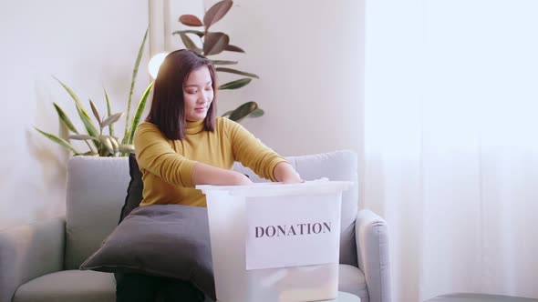 Asian Woman pressing phone using a credit card to pay online to reserve donation box delivery. Conce