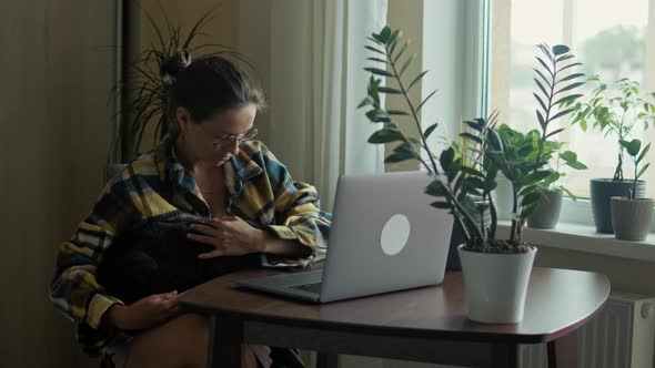 Woman Petting Her Cat At Home Office