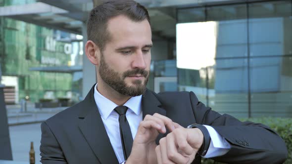 Businessman Using Smartwatch for Browsing Internet