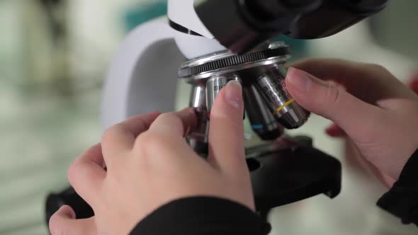 Close Up Of Examining Of Test Sample Under The Microscope In Laboratory