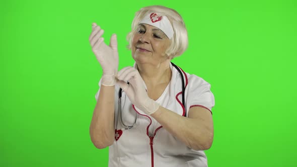 Elderly Caucasian Female Doctor Wearing Protective Gloves. Pandemic. Coronavirus