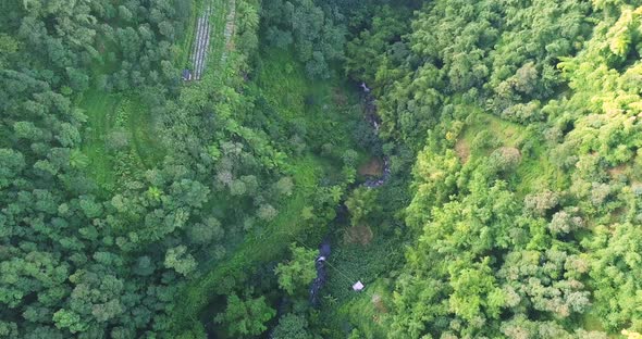 Aerial top down shot of idyllic river flowing in the idyllic valley of slope of Mount Sumbing,Indone