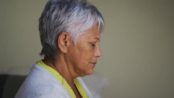 Senior mixed race woman with headache sitting touching brow