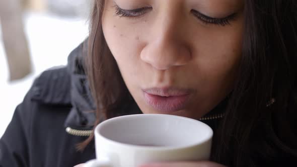Satisfying feeling of sipping tea in winter by a south asian woman
