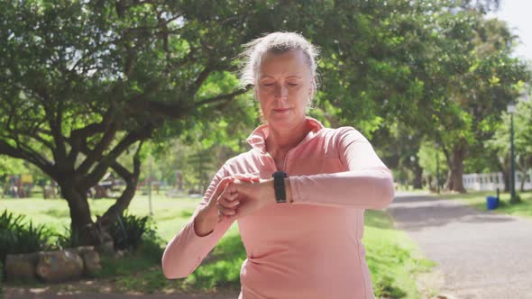 Senior woman using smartwatch in the park