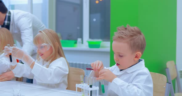 Teacher Explaining an Experiment to a High School Chemistry Class Together