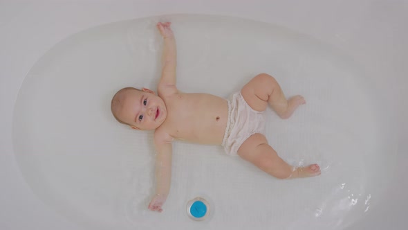 Top View of Funny Newborn Baby Swimming During Bathing.