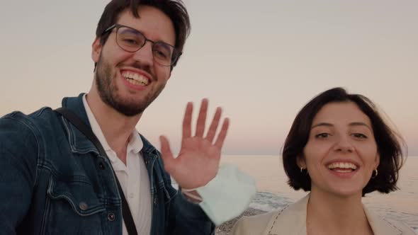 Couple takes a selfie on the beach with a mask