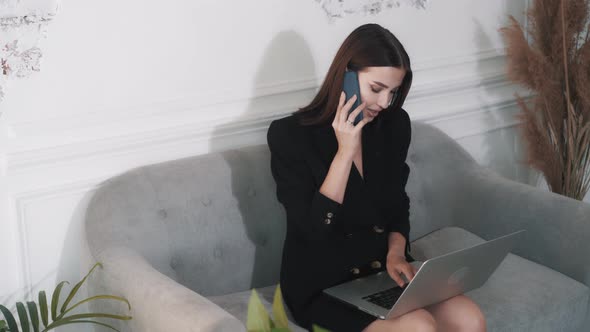 Confident Caucasian Young Brunette Talking on Phone with Her Clients 