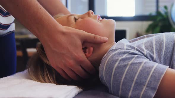 Physiotherapist giving head massage to a boy