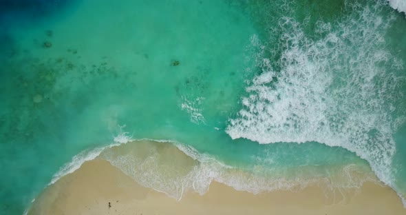 Wide overhead abstract view of a sandy white paradise beach and blue water background in 4K