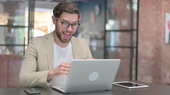 Successful Young Man Celebrating on Laptop