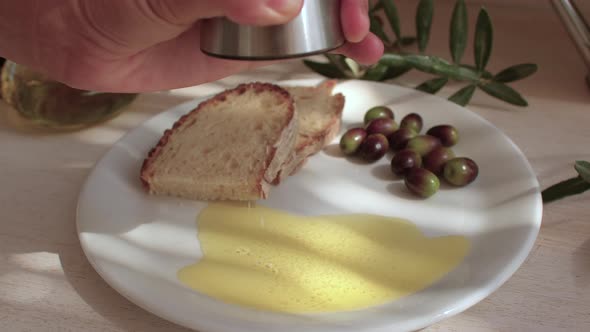 Preparation of Natural Food Hand Chef Moves Salt Mill on Butter in Dish