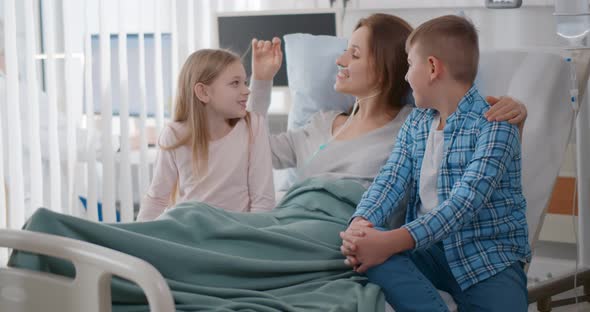 Little Girl and Boy Visiting Ill Mother in Hospital Room