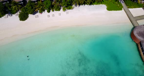 Daytime flying abstract view of a paradise sunny white sand beach and aqua blue water background in 