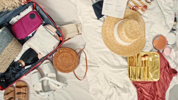 Top View of Suitcase and Clothes on Bed