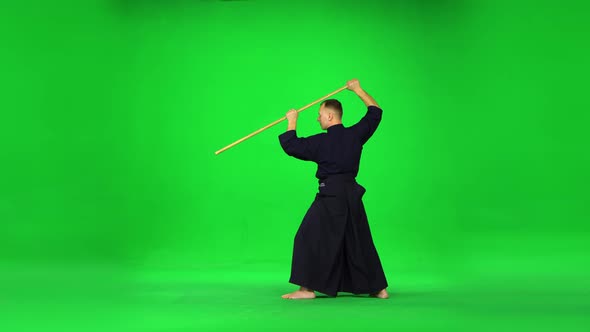Masculine Kendo Warrior Practicing Martial Art with the Bamboo Bokken on Green Screen.