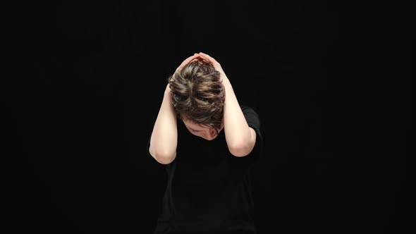 Middle Shot of Desperate Young Woman Holding Head in Hands Crying