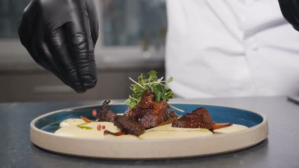 Chef in Black Gloves Adding Dry Spices to Mashed Potatoes and Meat