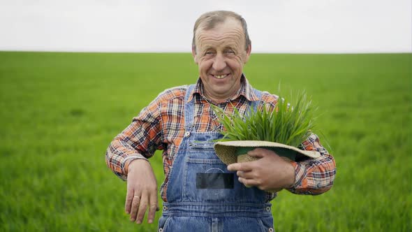 Smiling Farmer with Seedlings in Hat