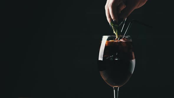 Mulled Wine in a Glass with Straws in Restaurant on Black Background