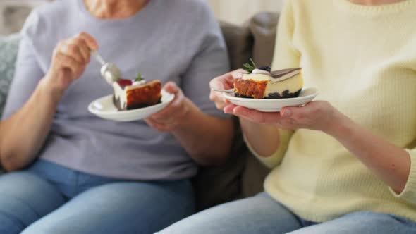 Old Mother and Adult Daughter Eating Cake at Home