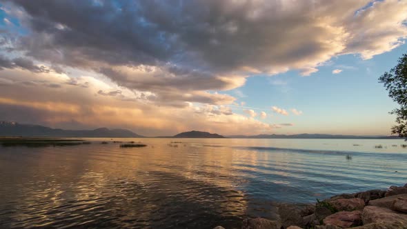 Time-lapse during sunset on Utah Lake with a boat moving through the water.
