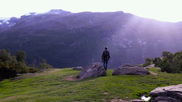 Man walking in a beautiful mountain scenery located in the Norwegian mountains, Europe.