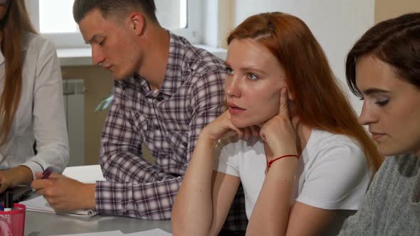 Red Haired Woman Looking Annoyed While Working on a Project at School