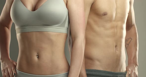 Closeup of Two Sportsmen Male and Female Athletes Chest Holding Stomach Showing Abdominal Abs