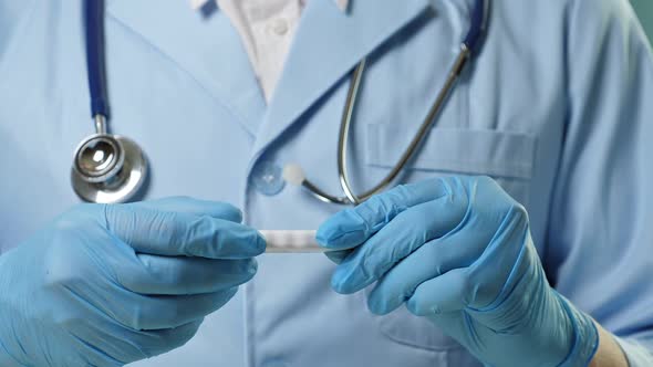 Doctor in Professional Medical Suit and Blue Gloves Checking Temperature By Digital Thermometer