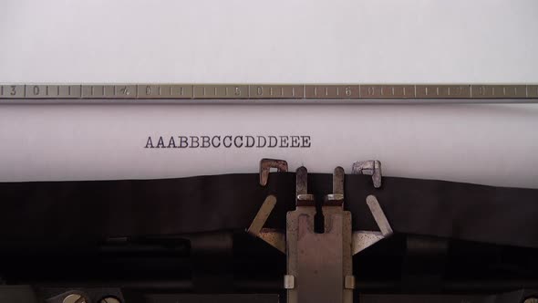 Typing alphabet letters A B C D E on retro typewriter. Close up.