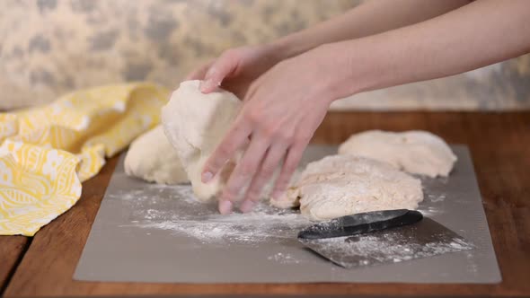 Female Hands Cut with a Scraper a Kneaded Dough on Working Surface