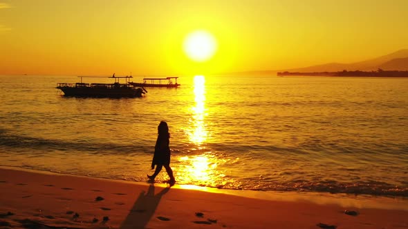 Single lady sunbathing on relaxing lagoon beach voyage by aqua blue ocean with white sandy backgroun