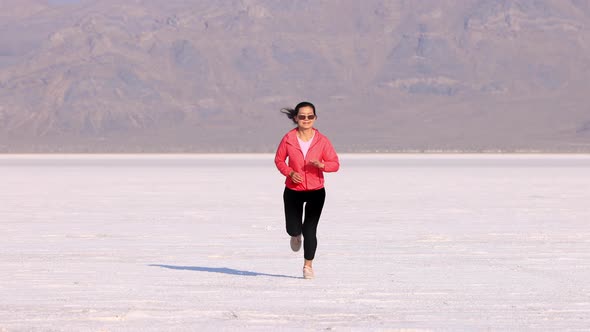 Asian woman jogging across the Bonneville Salt Flats flats