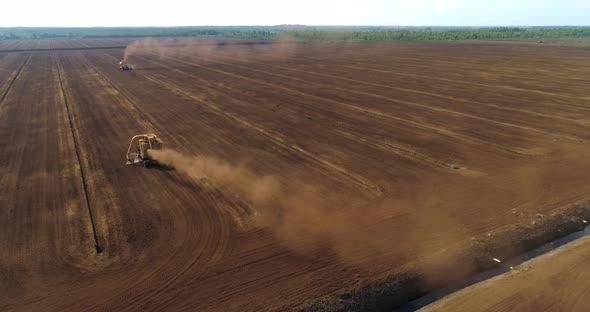 Peat Harvesting Machines Working on Field Collecting Peat Dust Aerial View