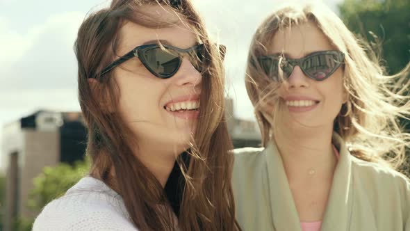 Two young beautiful women posing outdoors 