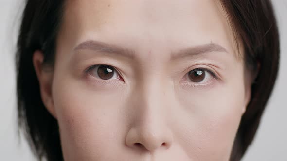 Cropped Shot Of Mature Korean Female Face Over Gray Background