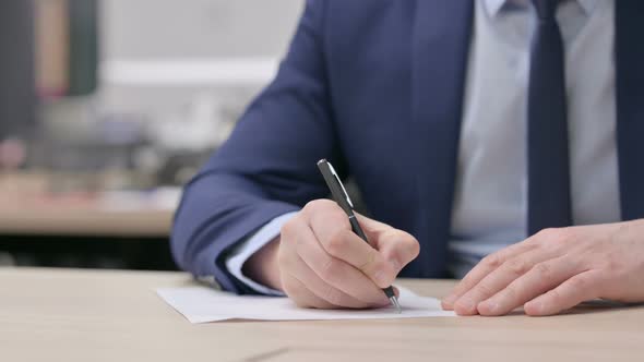 Hand Close Up of Businessman Writing on Paper