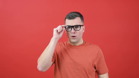 A Man in Glasses Looks Into the Camera As If He Can't See Well
