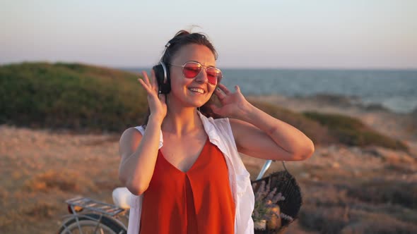 Medium Shot Happy Joyful Young Woman in Headphones and Sunglassessmiling Dancing in Slow Motion at