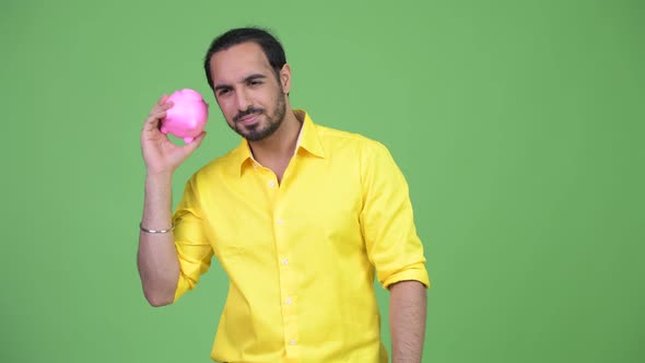 Young Bearded Indian Businessman Shaking the Piggy Bank