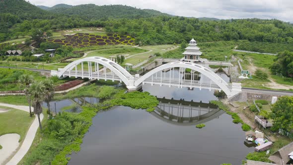 Aerial top view of Tha Chomphu White Bridge, Lamphun, Thailand with lake or river