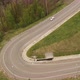 Two White Cars Drive on a Bend Along a Serpentine Mountain Road. Aerial Vertical Top View - VideoHive Item for Sale